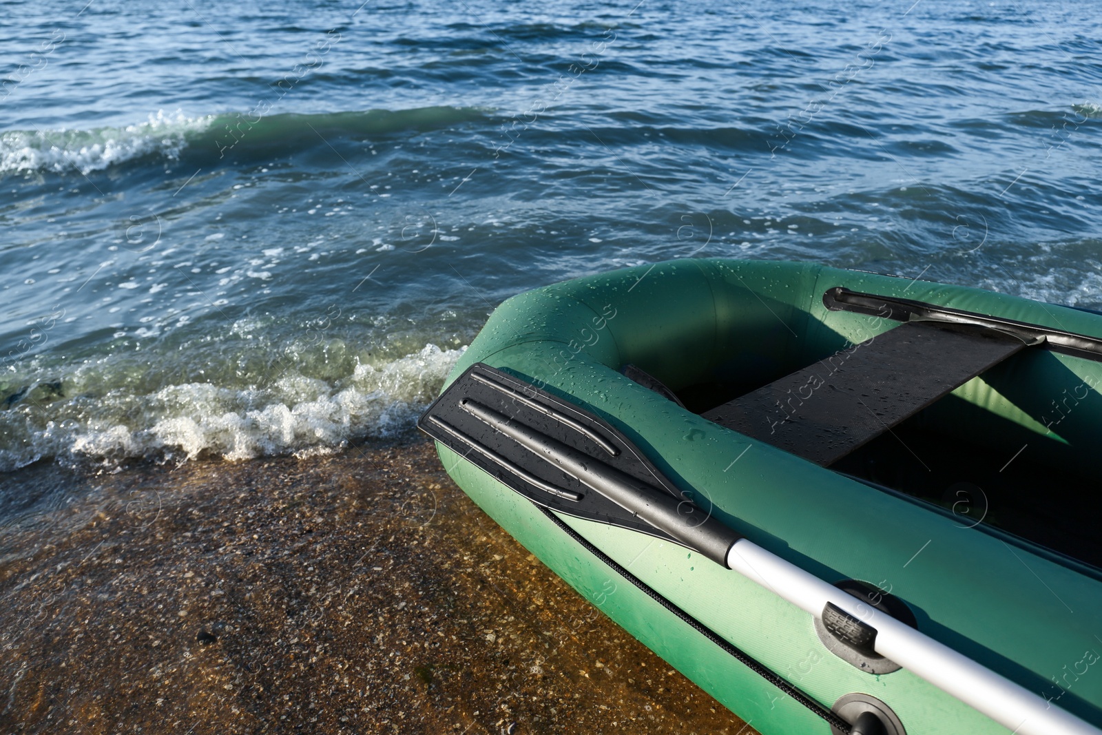 Photo of Inflatable rubber fishing boat on sandy beach near sea