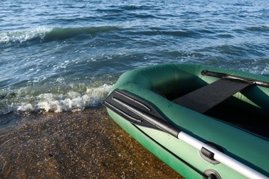 Inflatable rubber fishing boat on sandy beach near sea