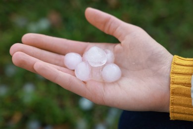 Photo of Woman holding hail grains after thunderstorm outdoors, closeup