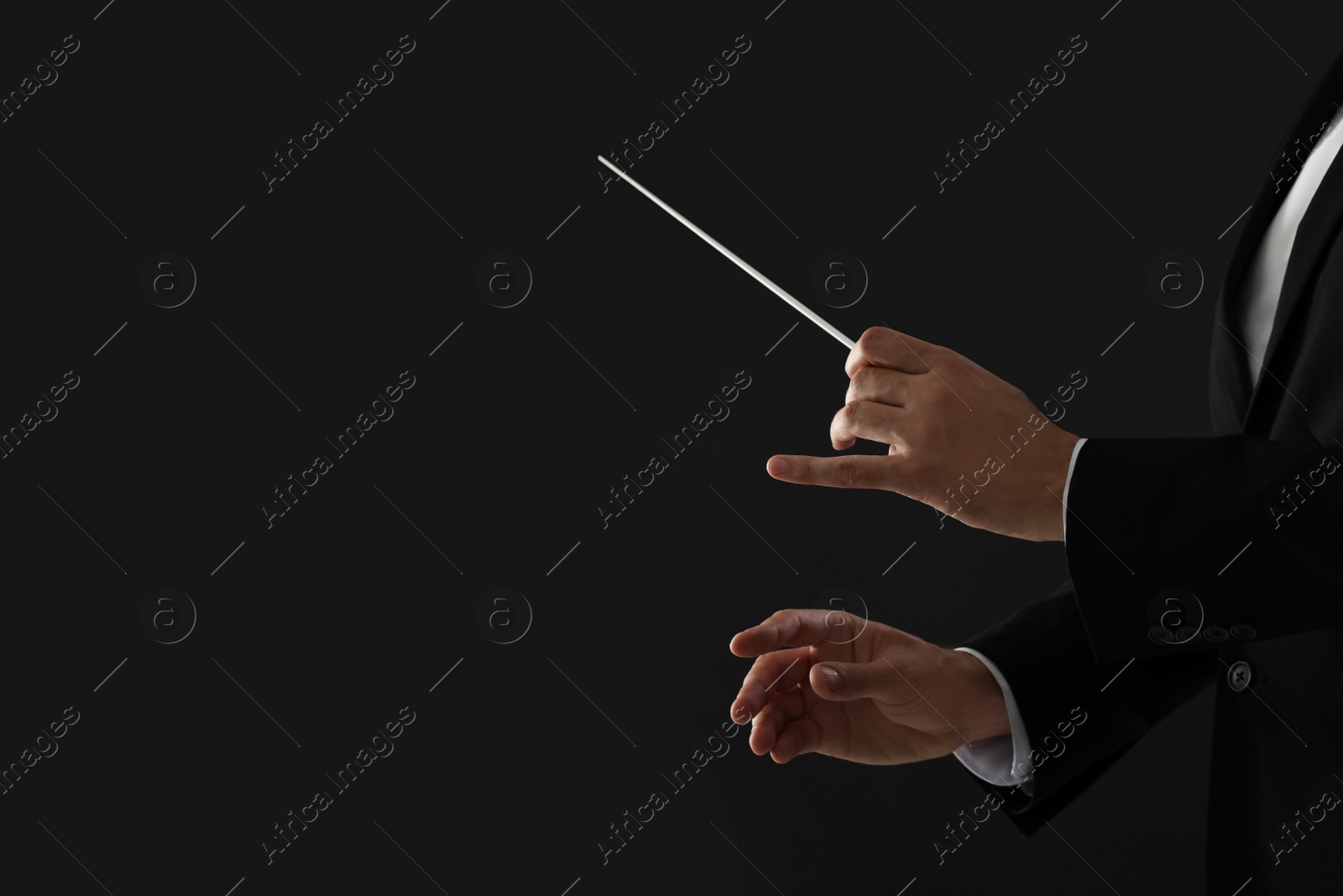 Photo of Professional conductor with baton on black background, closeup. Space for text