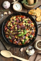 Delicious ratatouille in baking dish served on wooden table, flat lay