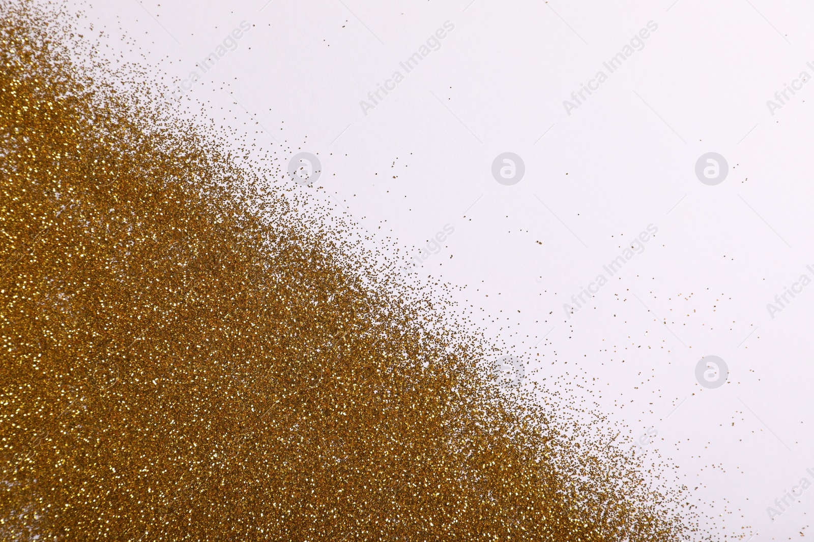 Photo of Shiny golden glitter on white background, top view