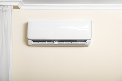 Modern air conditioner on white wall indoors