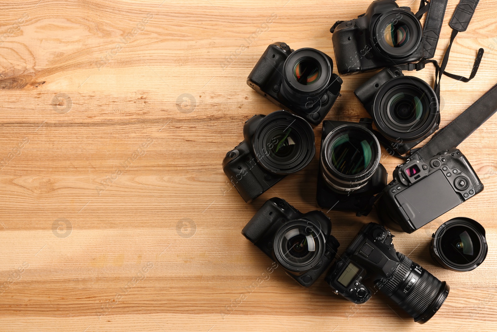 Photo of Modern different cameras on wooden table, flat lay. Space for text