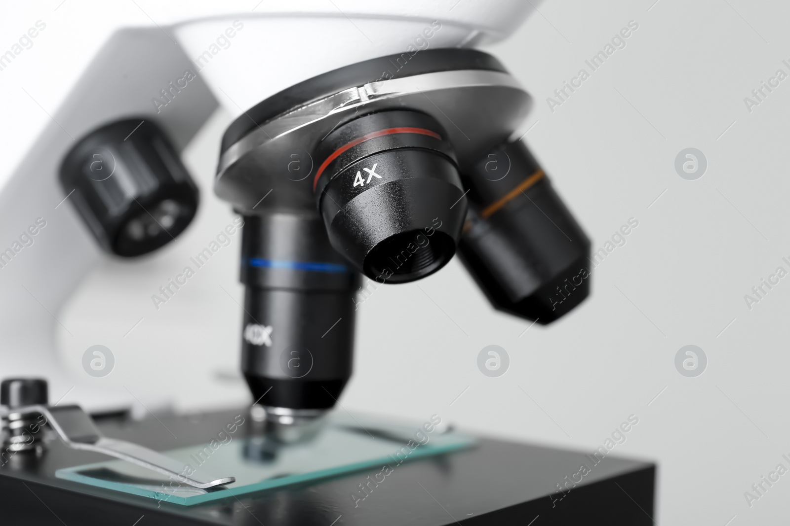 Photo of Modern medical microscope with glass slide on grey background, closeup