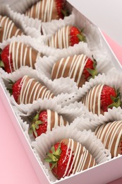 Photo of Box with delicious chocolate covered strawberries on pink background, closeup