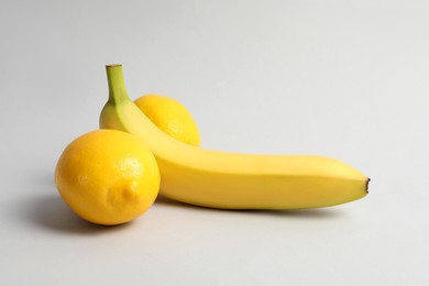 Photo of Banana and lemons symbolizing male genitals on light grey background. Potency concept