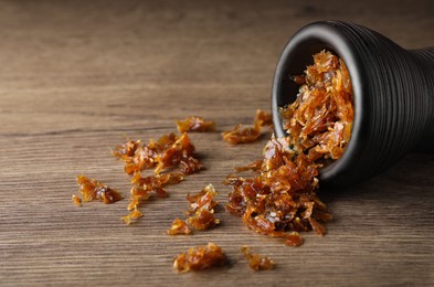 Photo of Clay bowl of hookah with aromatic tobacco on wooden table, closeup