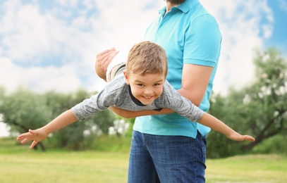 Man playing with his child outdoors. Happy family