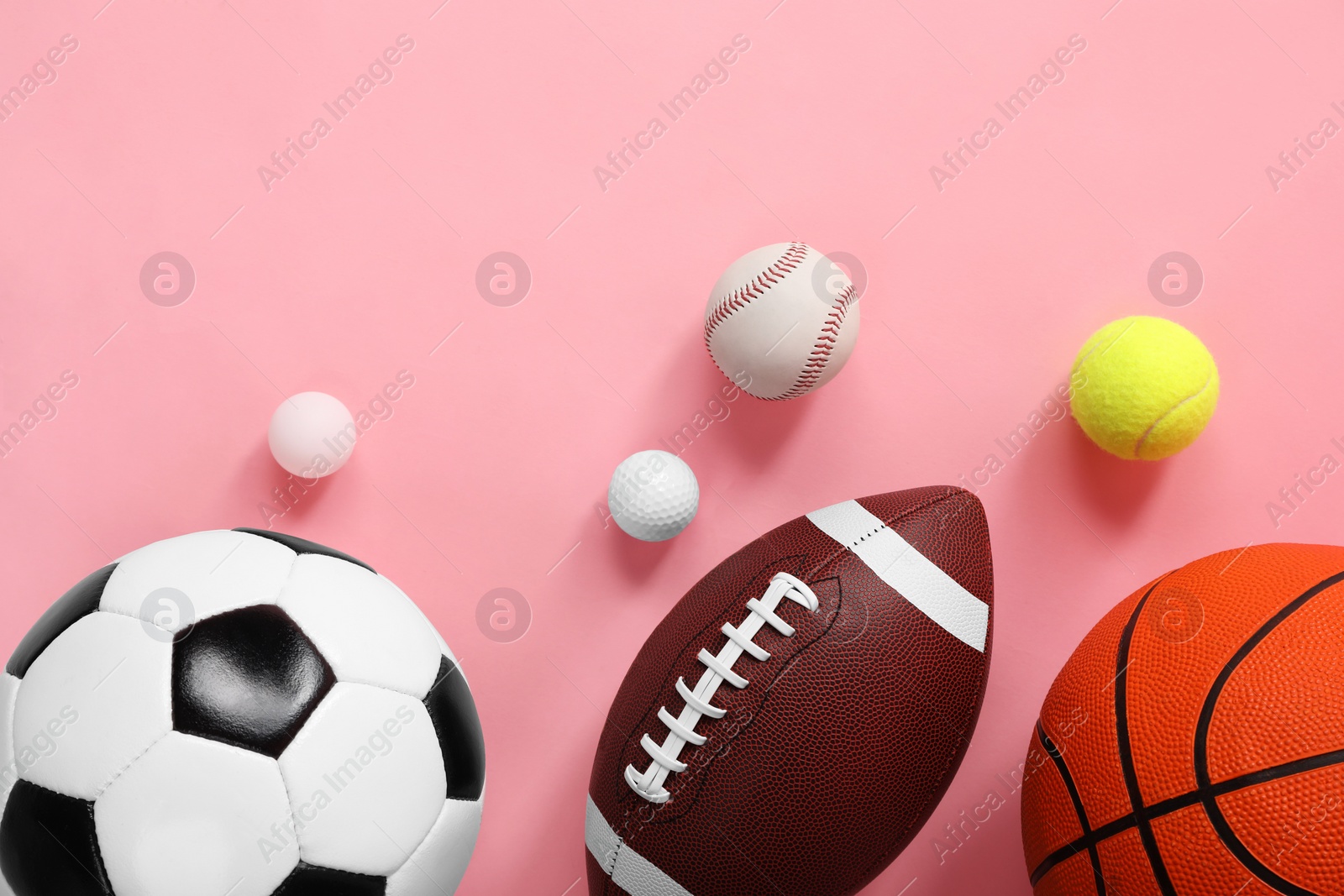 Photo of Many different sports balls on pink background, flat lay. Space for text