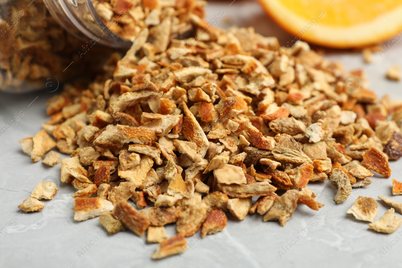 Photo of Dried orange zest seasoning on light grey table, closeup