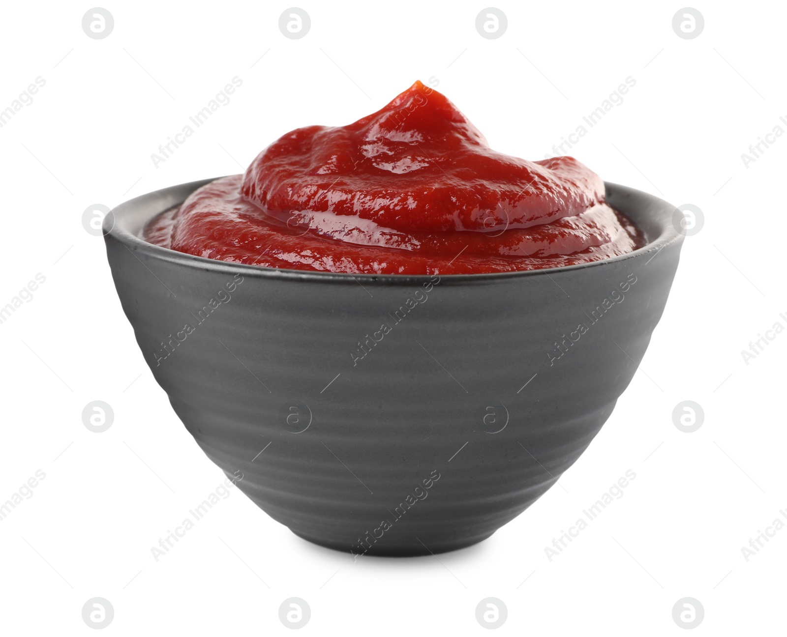 Photo of Tasty ketchup in bowl isolated on white