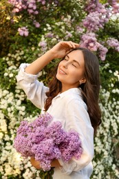 Photo of Attractive young woman with lilac flowers outdoors