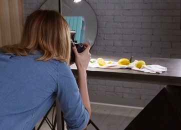 Photo of Woman taking photo of food with professional camera in studio