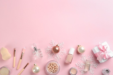 Flat lay composition with decorative cosmetic products on pink background, space for text. Winter care