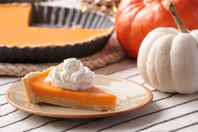 Photo of Piece of fresh homemade pumpkin pie with whipped cream on table