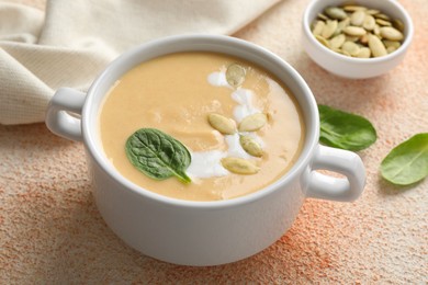Photo of Healthy cream soup high in vegetable fats on color textured table, closeup