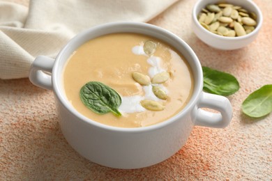 Healthy cream soup high in vegetable fats on color textured table, closeup