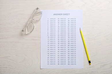 Photo of Flat lay composition with answer sheet on wooden background