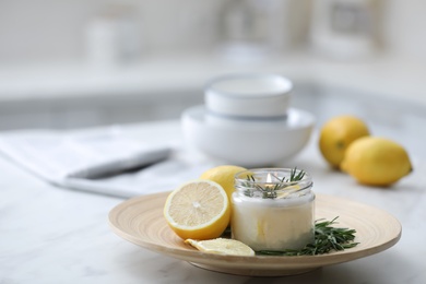 Natural homemade mosquito repellent candle and ingredients on white table