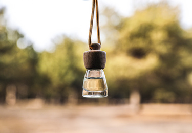 Car air freshener hanging on blurred view, closeup