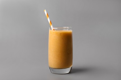Photo of Glass with delicious fresh fruit smoothie on grey background