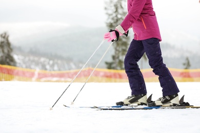 Photo of Female skier on slope at resort, closeup with space for text. Winter vacation