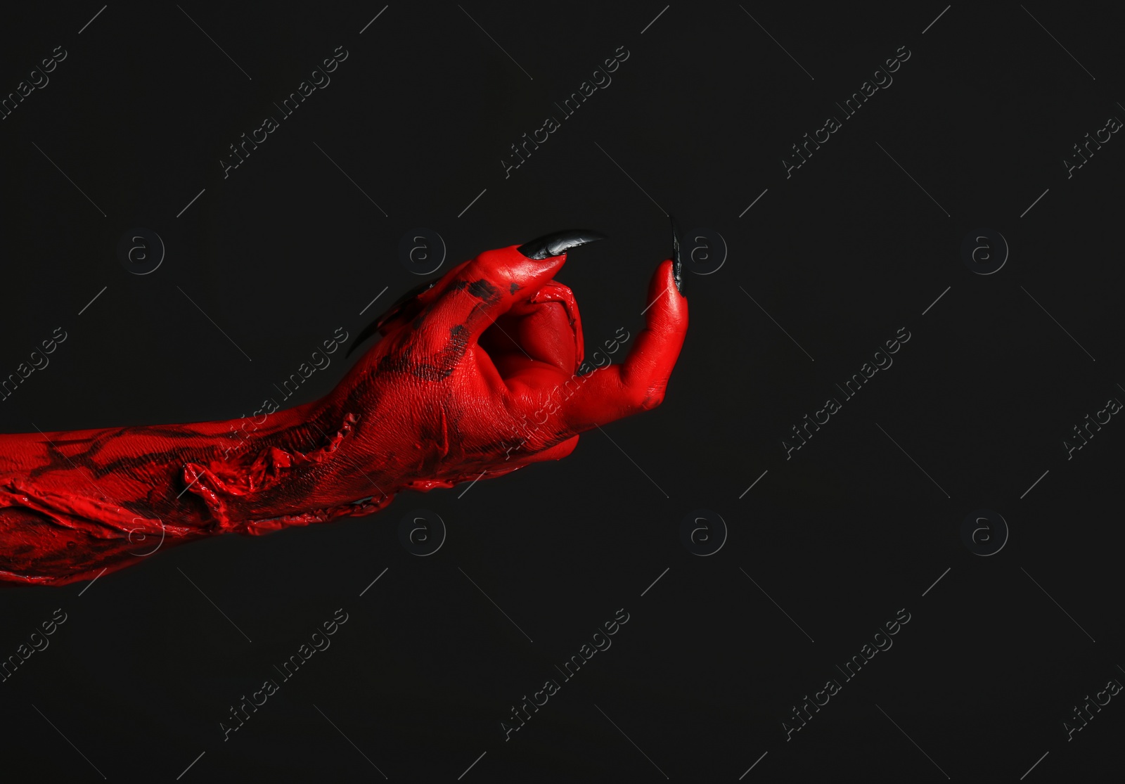 Photo of Scary monster on black background, closeup of hand with space for text. Halloween character