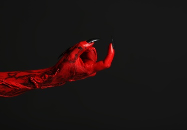 Photo of Scary monster on black background, closeup of hand with space for text. Halloween character