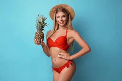 Photo of Pretty young woman wearing stylish bikini with pineapple on blue background