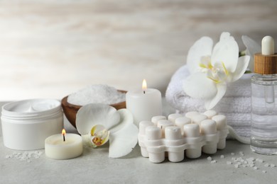 Photo of Beautiful composition with different spa products, burning candles and flowers on light grey table