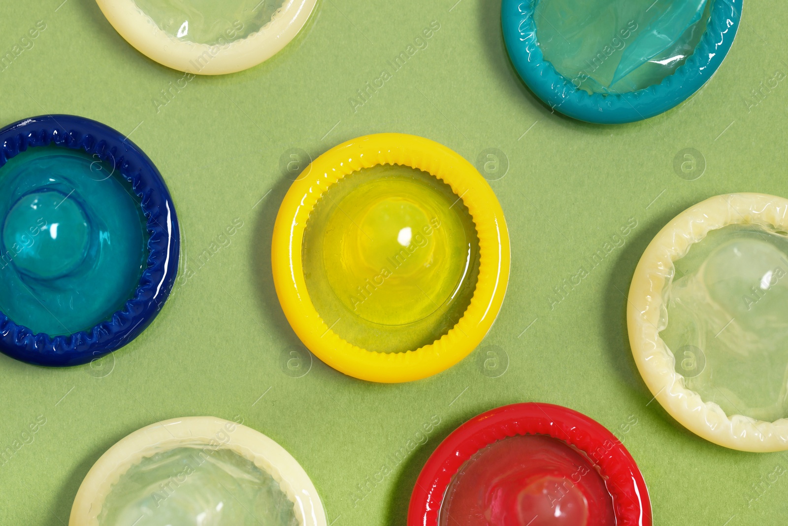 Photo of Condoms on light green background, top view. Safe sex