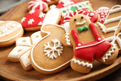 Photo of Tasty homemade Christmas cookies on wooden plate, closeup view