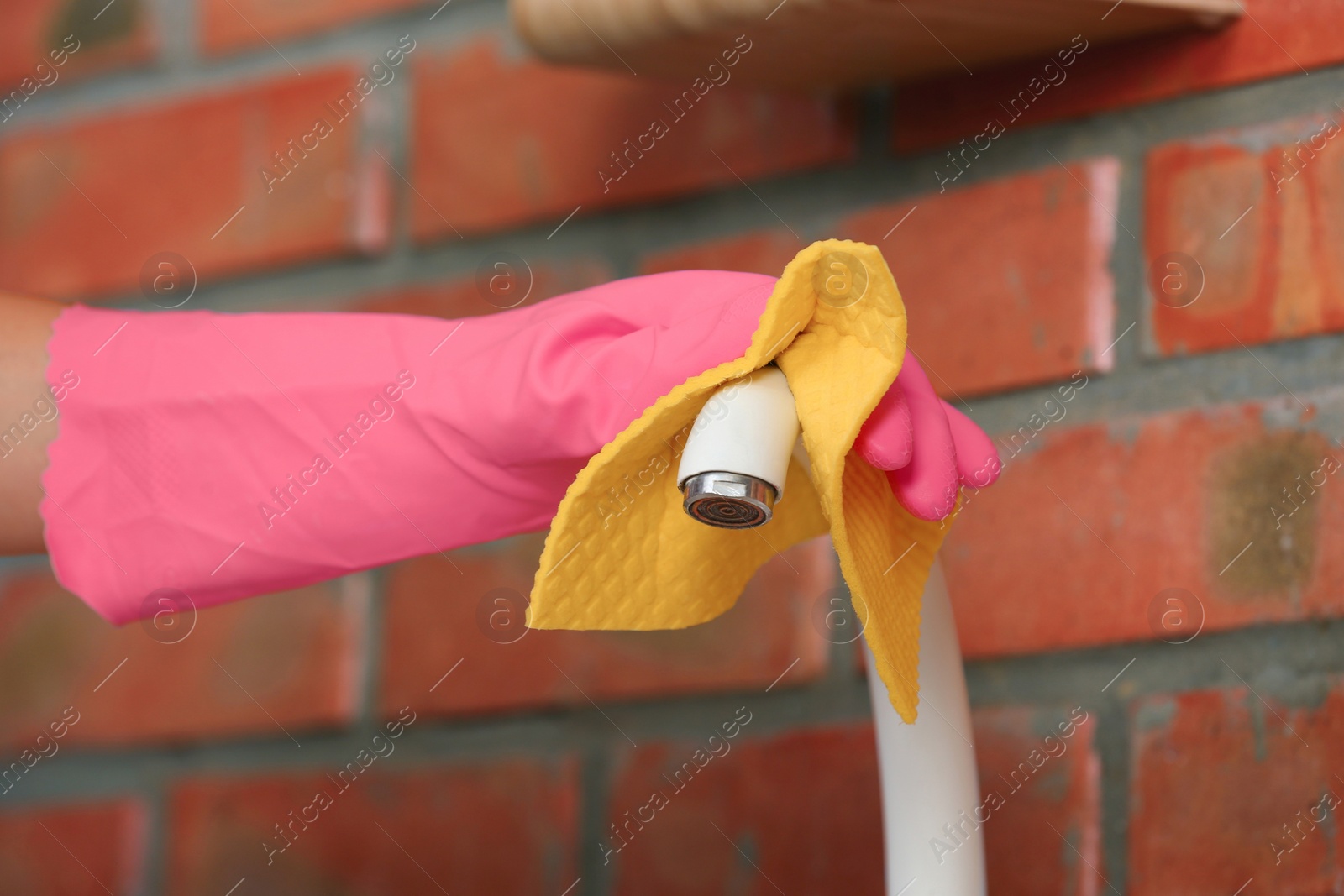 Photo of Woman cleaning tap with rag, closeup view