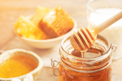 Image of Honey pouring from dipper into jar, closeup