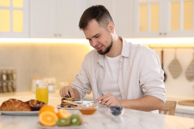 Photo of Smiling man having tasty breakfast at home