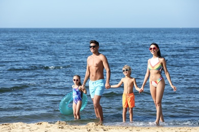 Photo of Happy family with inflatable ring in sea. Summer holidays