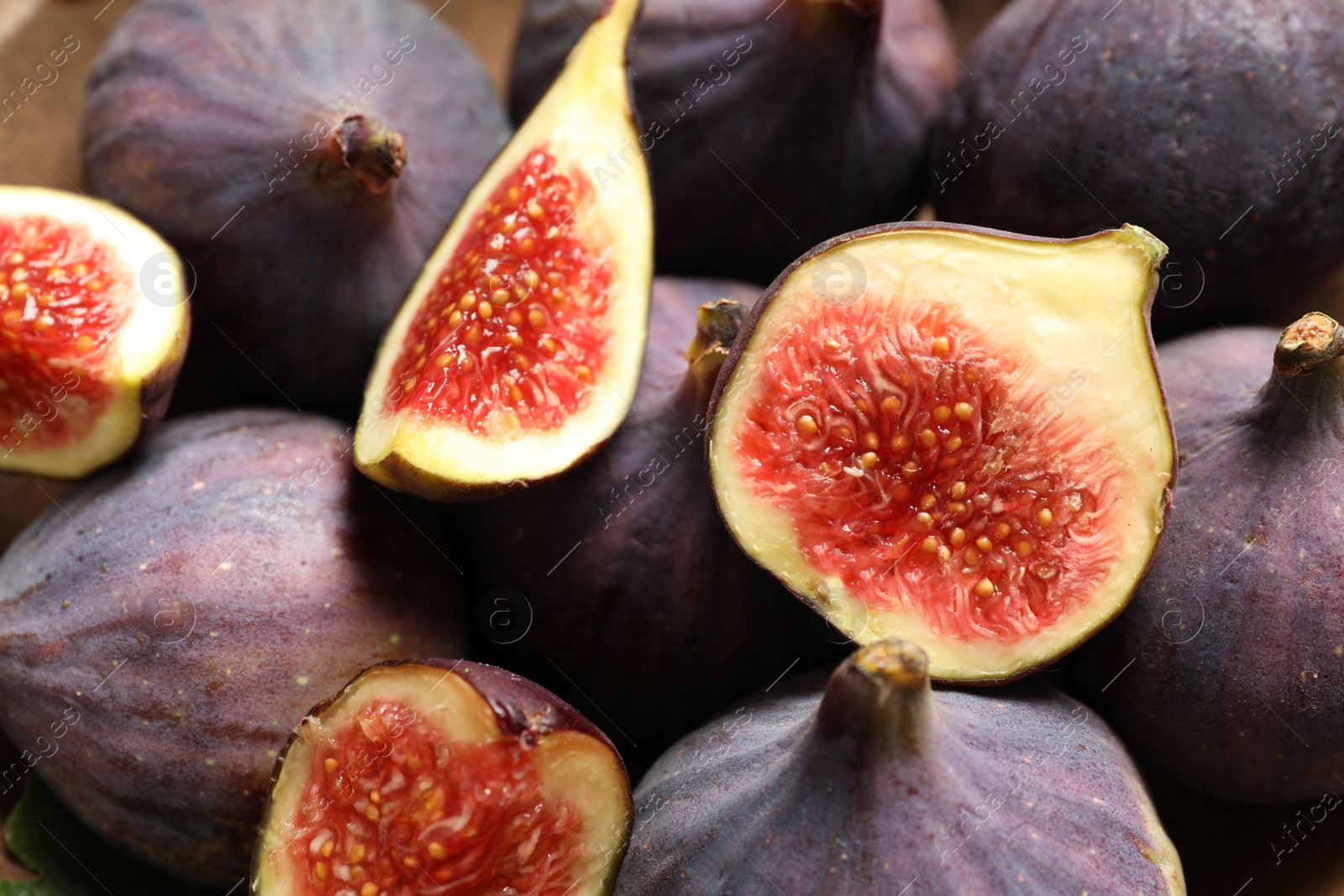 Photo of Whole and cut tasty fresh figs as background, closeup