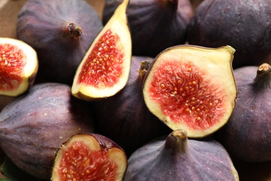 Whole and cut tasty fresh figs as background, closeup