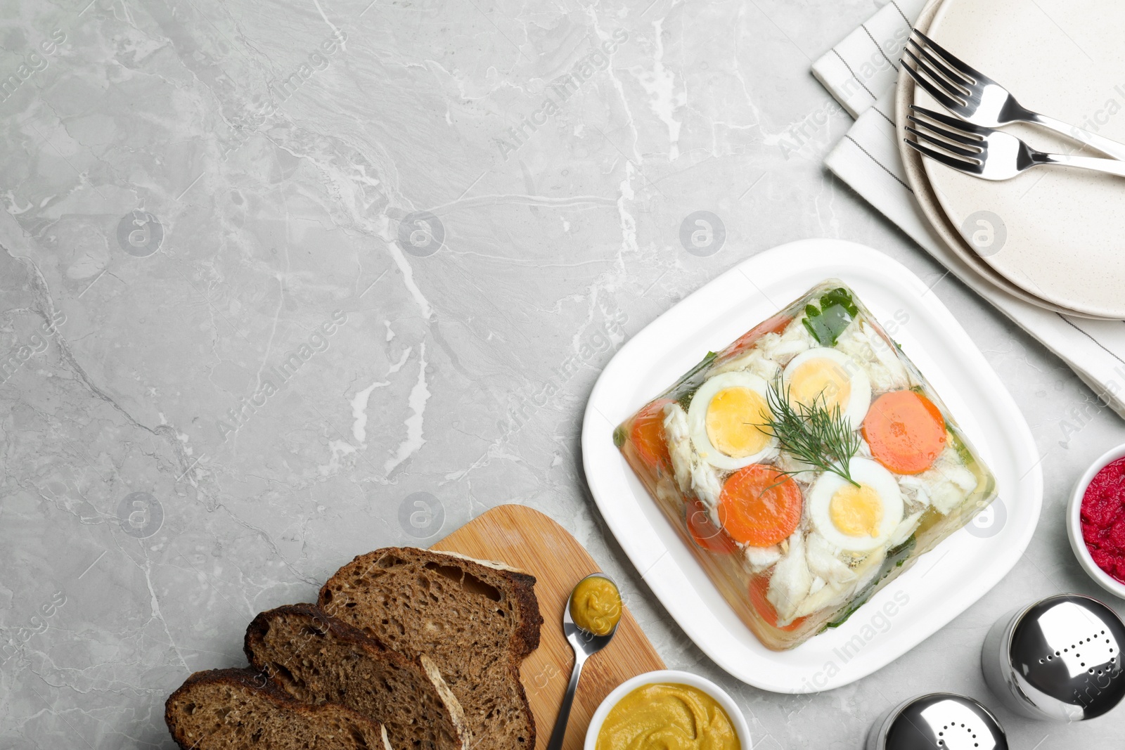 Photo of Delicious fish aspic served on grey marble table, flat lay. Space for text