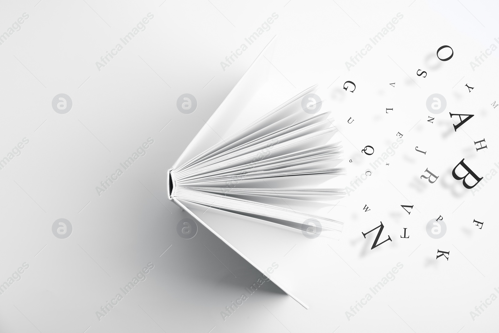 Image of Open book with letters flying out of it on white background, top view