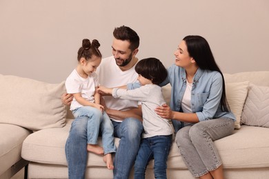 Photo of Happy family resting on sofa in living room