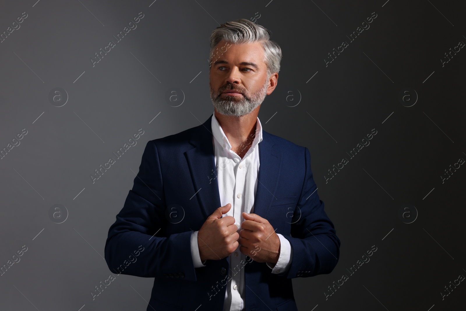 Photo of Portrait of confident man with beautiful hairstyle on dark background