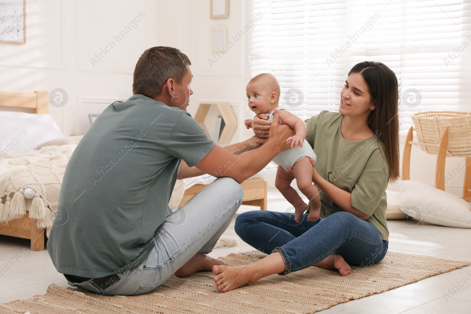 Photo of Happy family with their cute baby on floor in bedroom