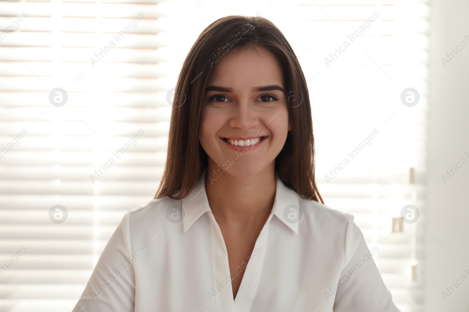 Photo of Young woman talking to her coworkers through video conference in office, view from webcam