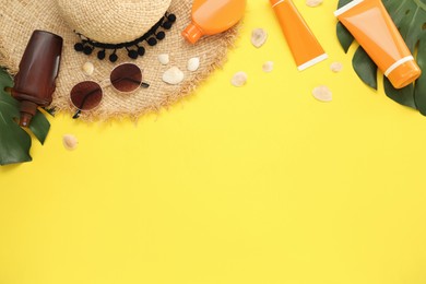 Photo of Sun protection products and beach accessories on yellow background, flat lay. Space for text