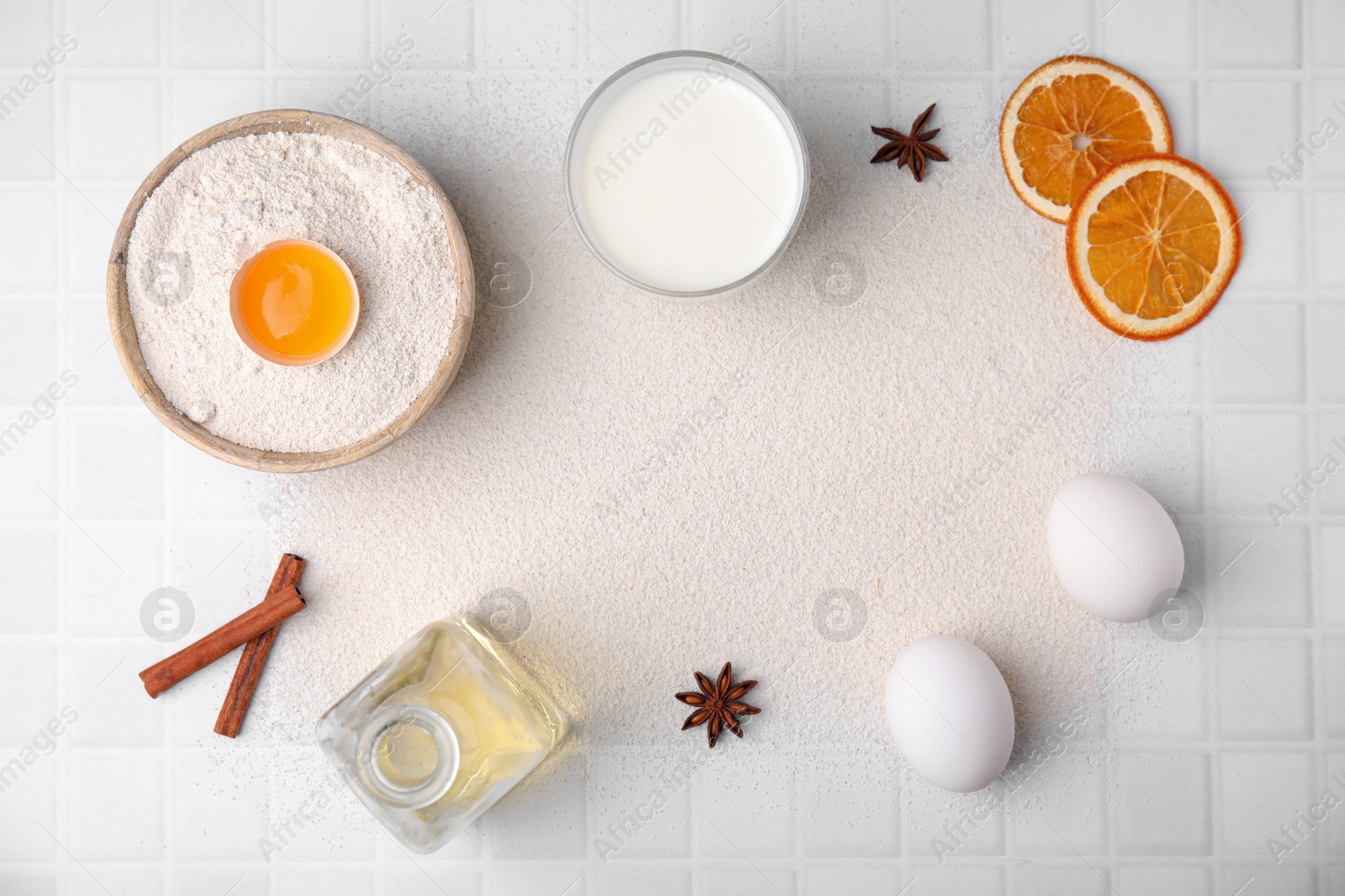 Photo of Frame made of flour and ingredients on white tiled table, flat lay. Space for text