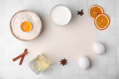 Frame made of flour and ingredients on white tiled table, flat lay. Space for text