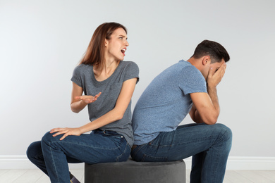 Photo of Woman shouting at her boyfriend on light background. Relationship problems
