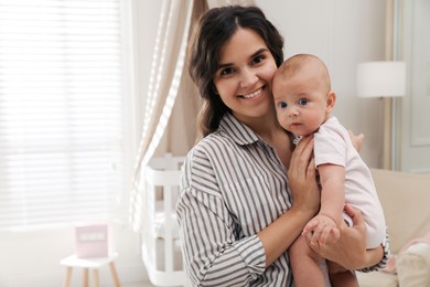 Happy young mother with her cute baby at home